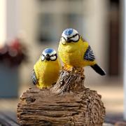 Två kvittrande blåmesar på en trädstubbe